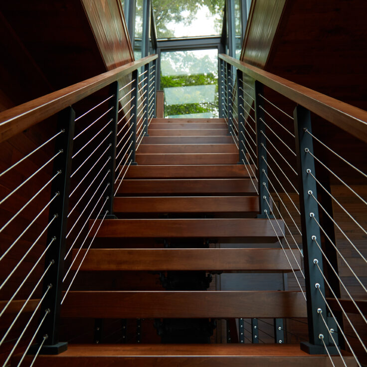 Clear coated treads and cable railing on floating stairs