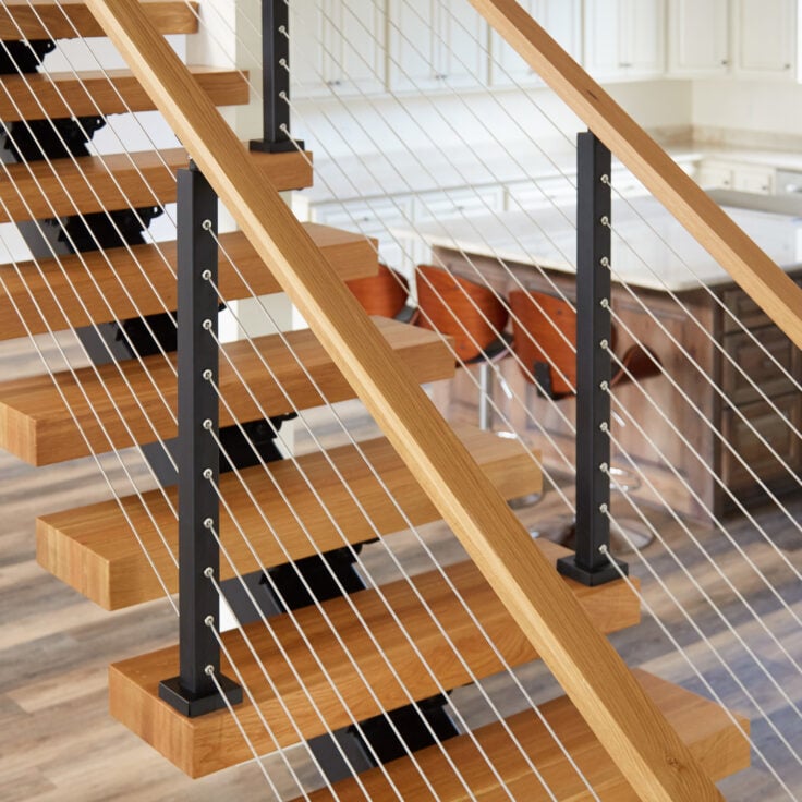 Cable Railing on Floating Stairs featuring White Oak Handrail & Black Powder Coated Posts