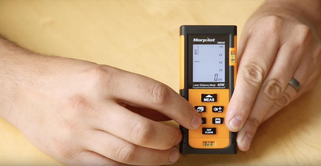 Hands Holding a Laser Measurement Tool 