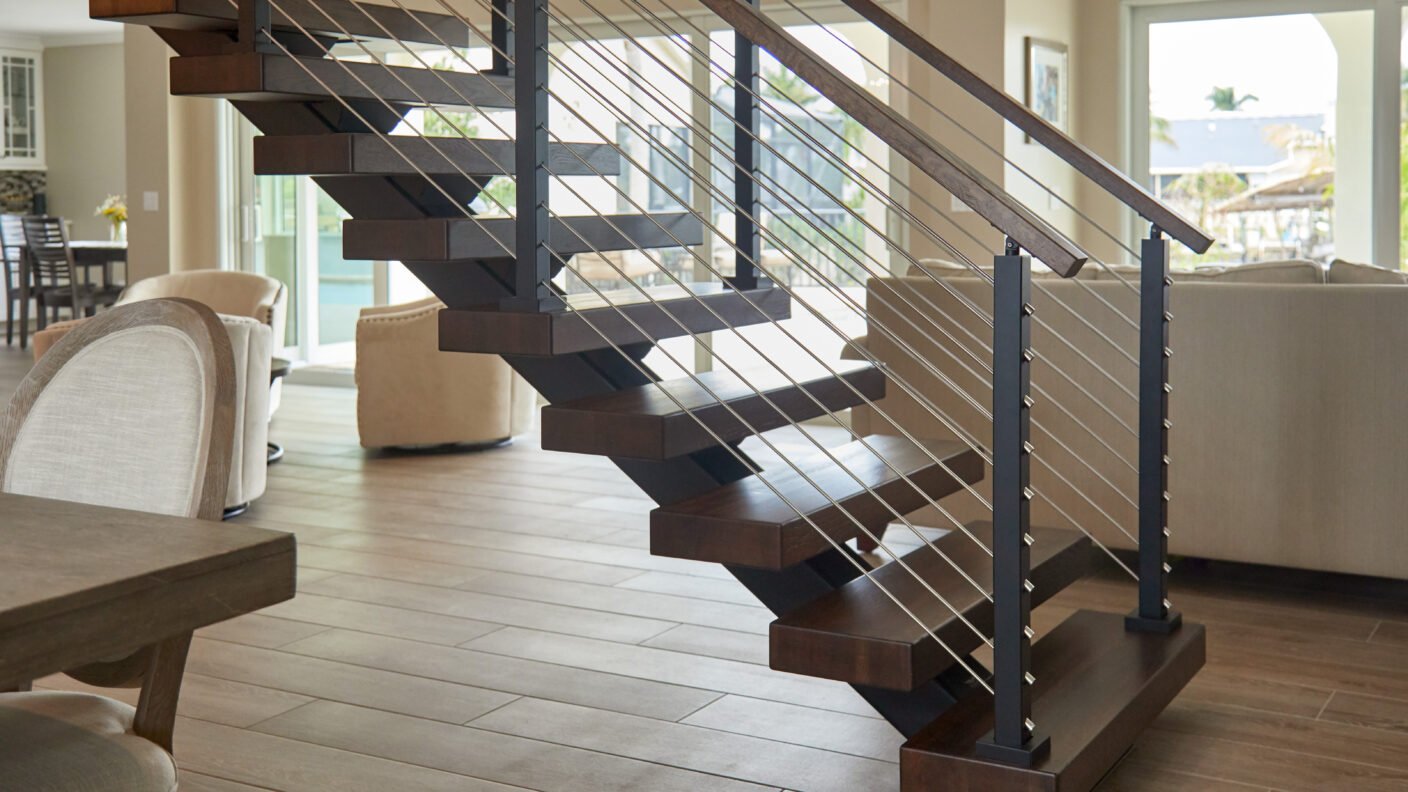 Floating stairs featuring stained white oak treads and rod railing.