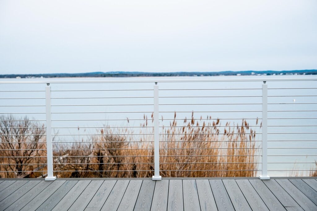 White cable deck railing on a deck in a cold, coastal environment